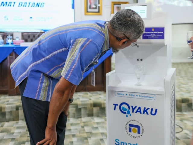 Sekda Jateng, Sumarno saat memperhatikan cara kerja alat sebelum mencoba air minum dari ToyaKU. Foto: dokumentasi